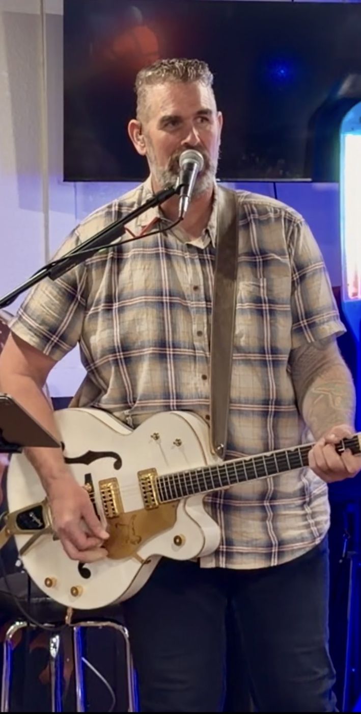 Randy playing guitar and singing at a live event